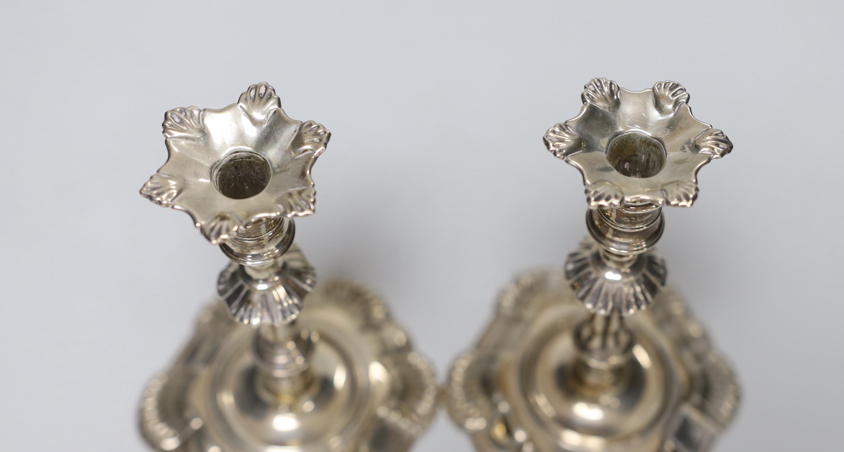 A pair of George II cast silver taper sticks, with unmarked nozzles, by John Cafe, London 1749/1750, 12.6cm, 11.7oz.